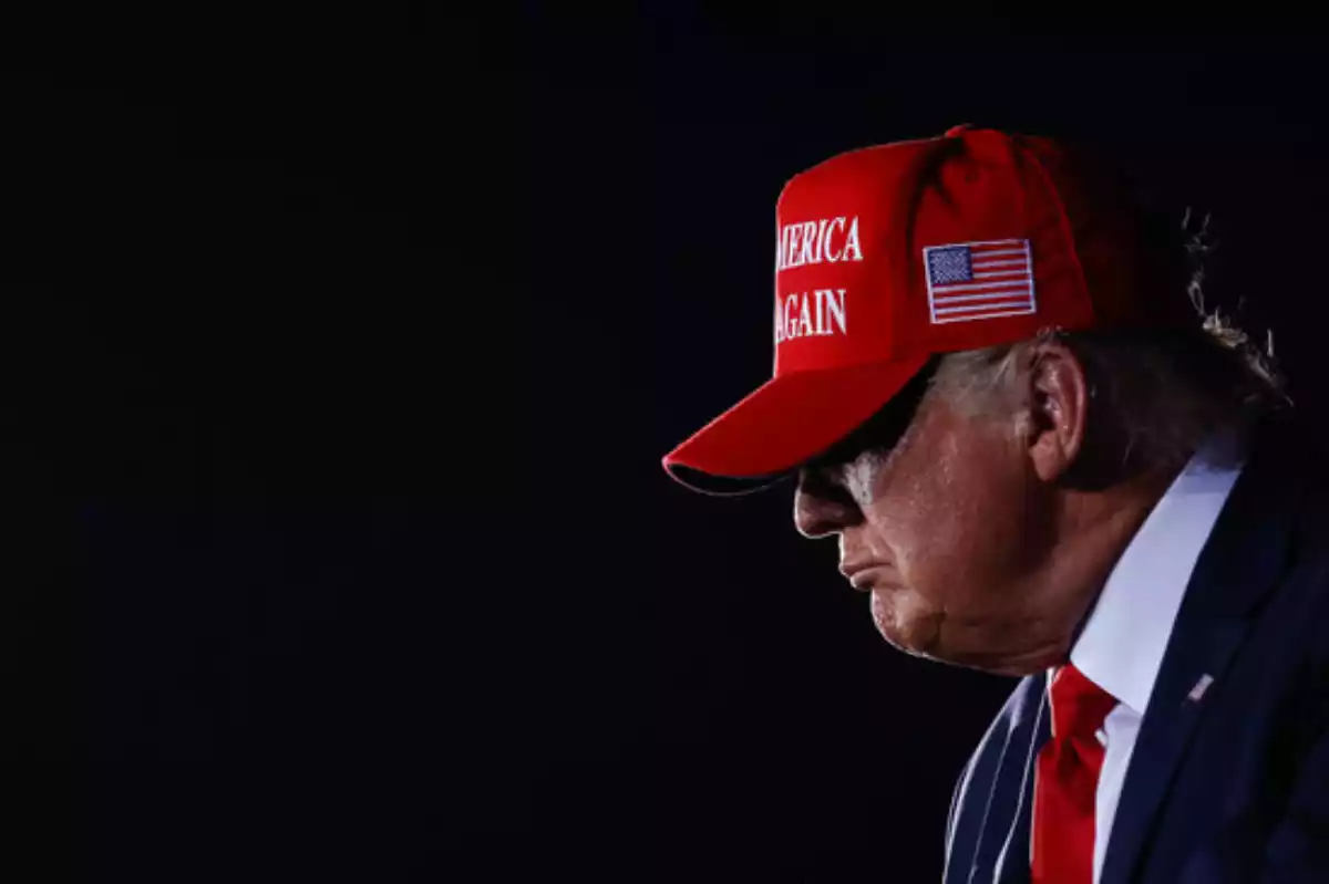 Donald Trump, amb una gorra amb el lema 'Make America Great Again' i el fons fosc