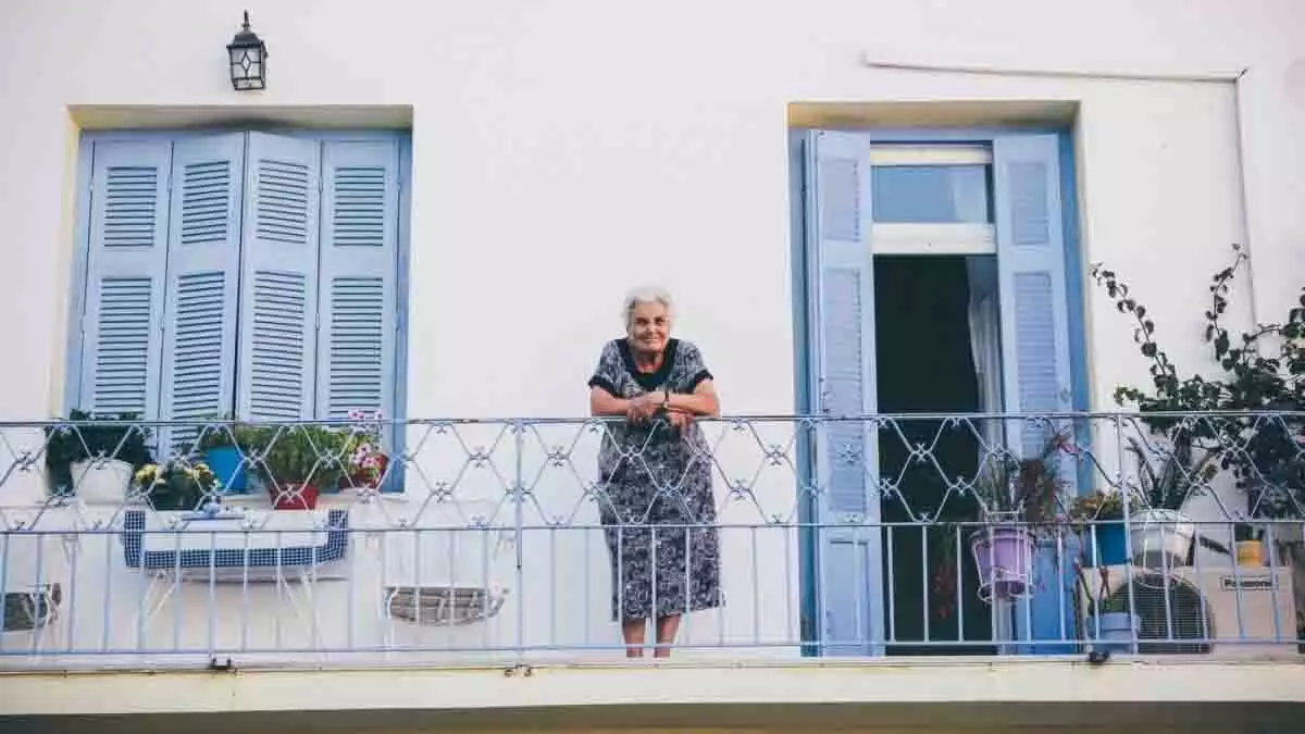 Mujer mayor en un balcón.
