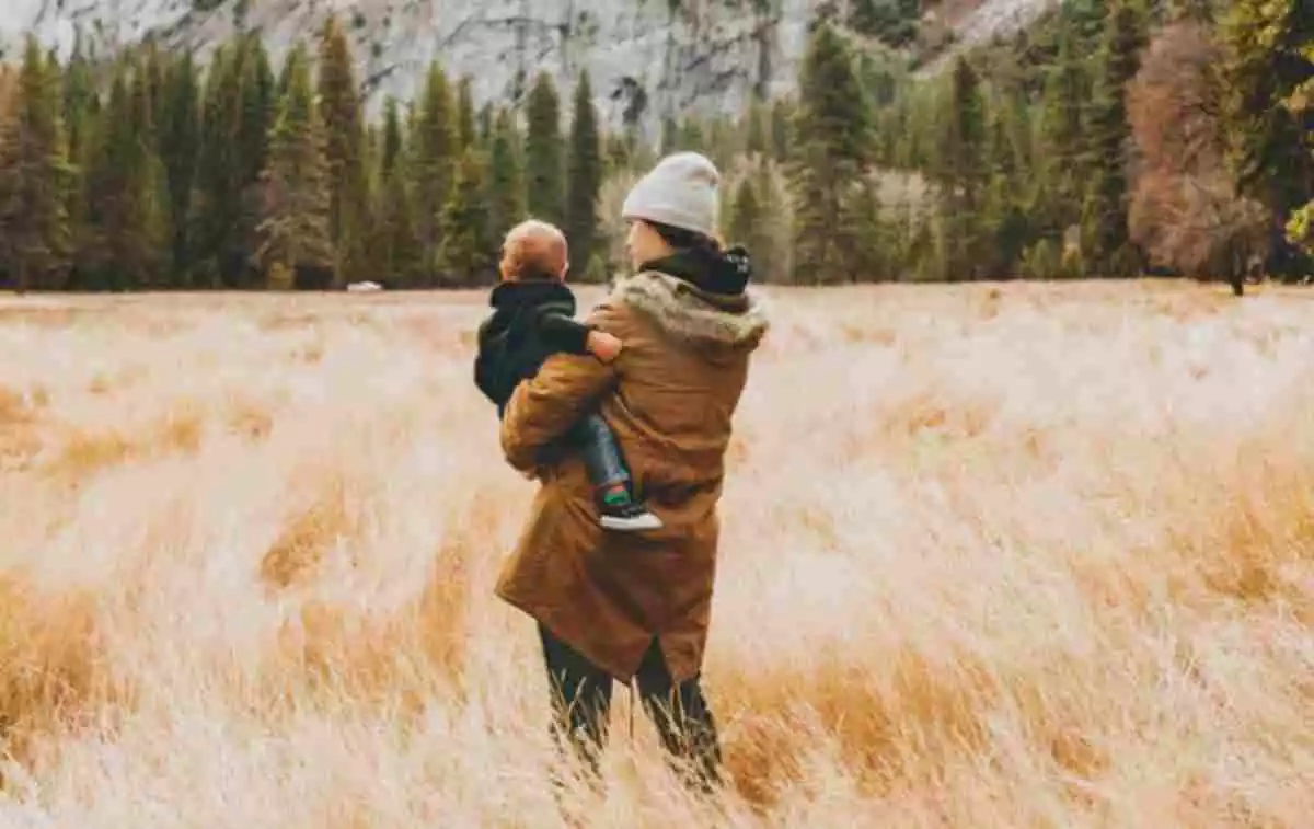 Madre con su hijo pequeño en brazos en el campo