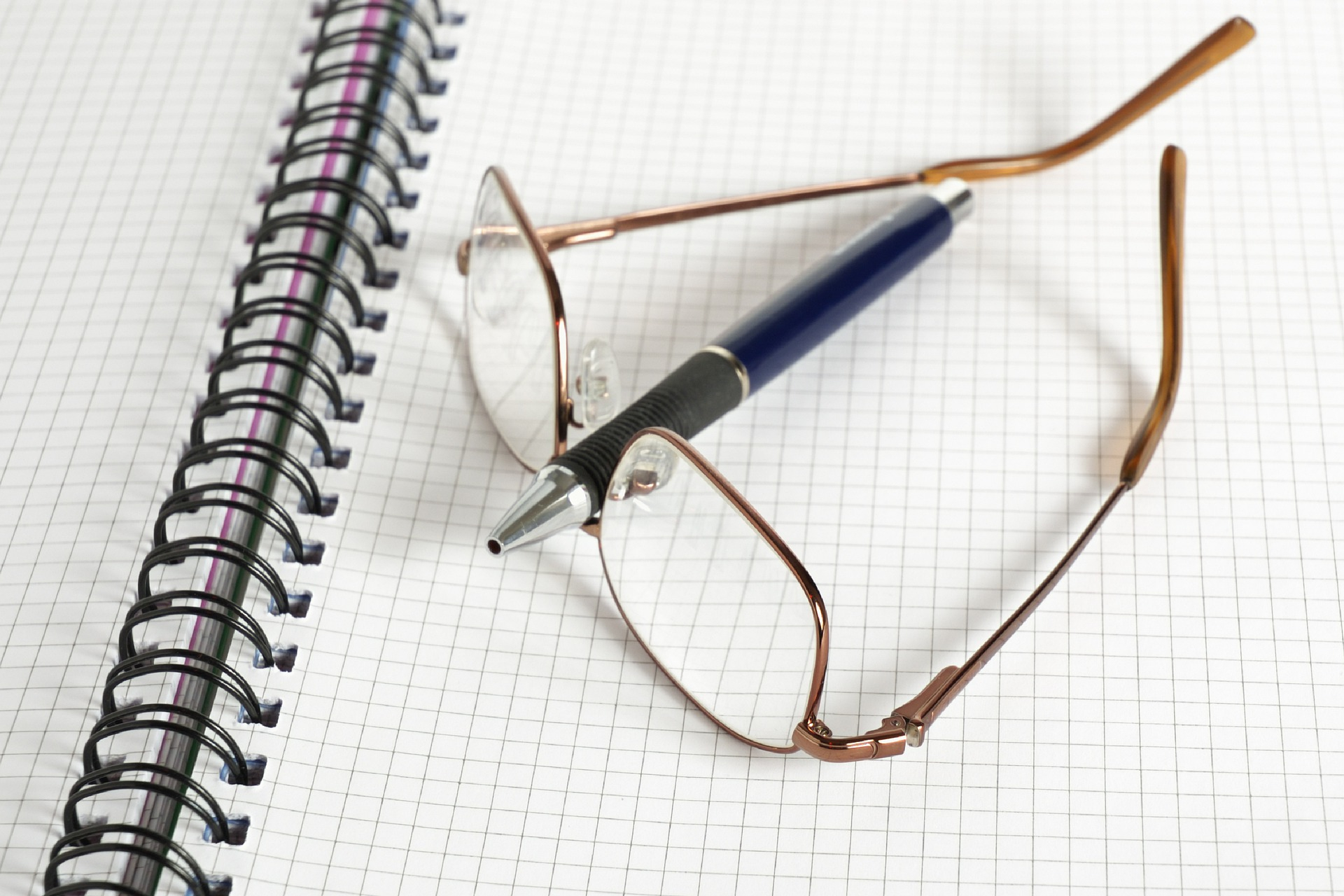 Unas gafas y un bolígrafo colocados sobre una libreta de matemáticas