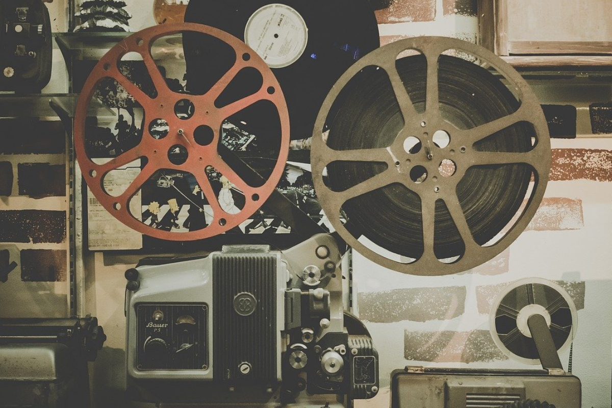 Un proyector con el carrete colocado en su posición reproduciendo una película en un cine